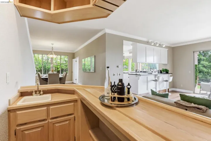Kitchen with pendant lighting, wooden counters, crown molding, and plenty of natural light