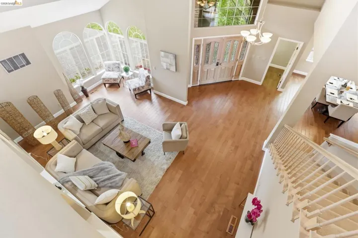 Living area with a chandelier, a high ceiling, wood finished floors, and french doors