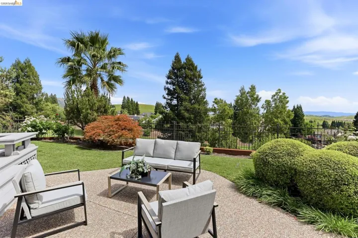 Fenced backyard with outdoor seating, a patio, and a mountain view