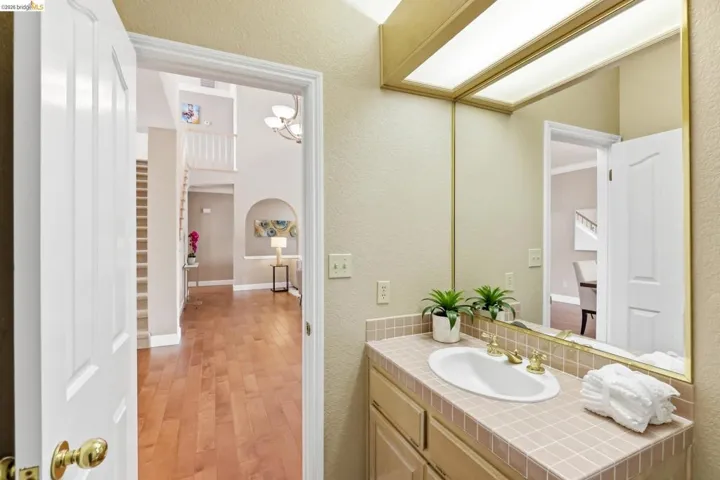 Bathroom featuring vanity, a textured wall, and light wood-style flooring
