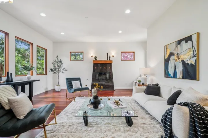 Living room featuring a tiled fireplace, dark wood-type flooring, and recessed lighting
