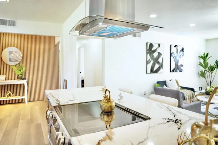 Kitchen featuring island range hood, electric range, light stone counters, light wood finished floors, and recessed lighting