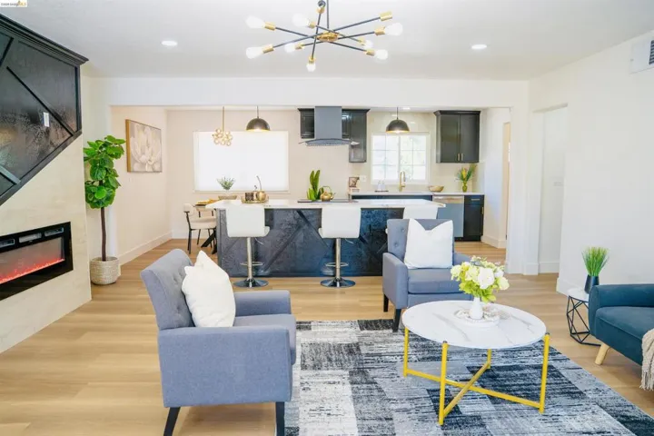 Living area with light wood-type flooring, a fireplace, and suspended lighting