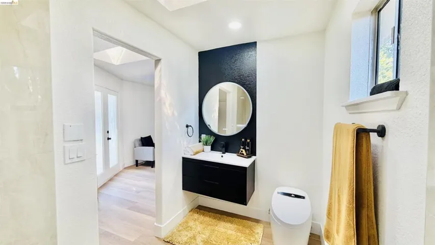 Bathroom featuring vanity, light wood-style floors, and a skylight