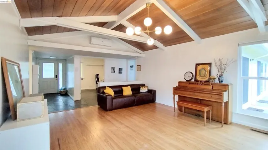 Living area with a wood ceiling with exposed beams, light wood-style flooring, and suspended lighting