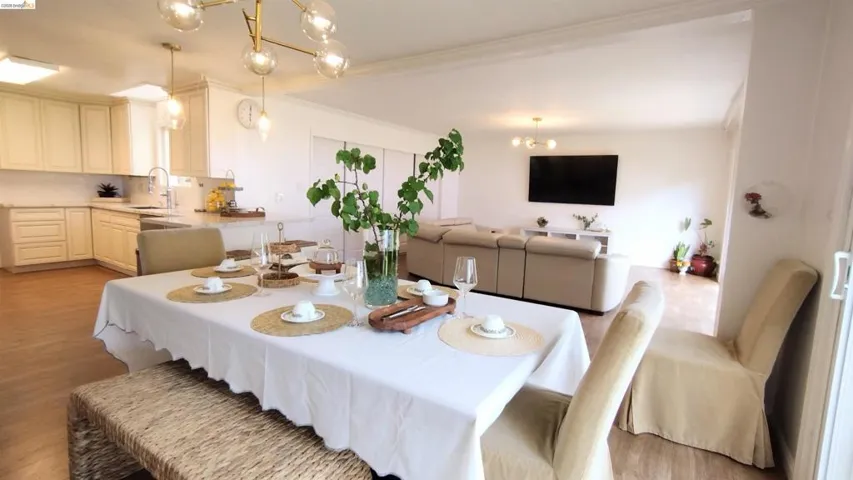 Dining area with a chandelier, light wood finished floors, and ornamental molding