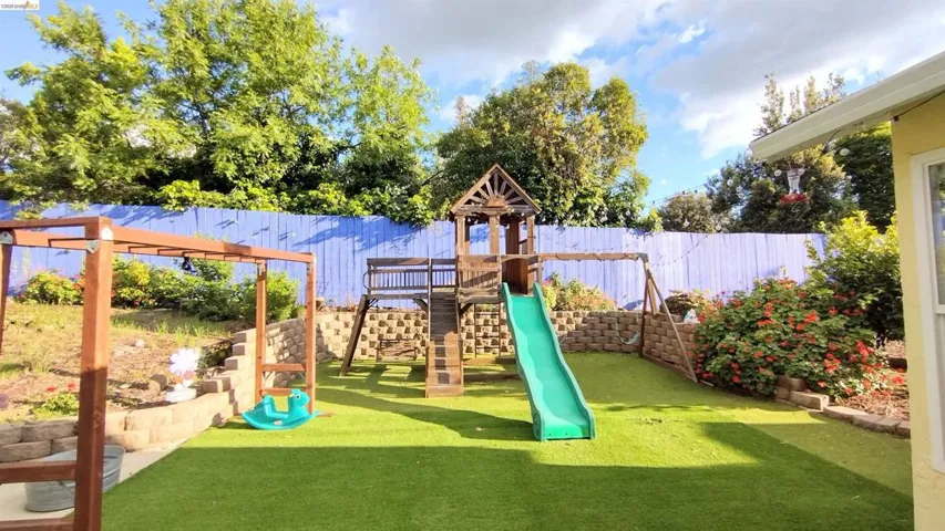 View of jungle gym with a fenced backyard, a pergola, and a patio