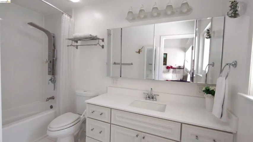 Bathroom featuring vanity and shower / bath combination with curtain