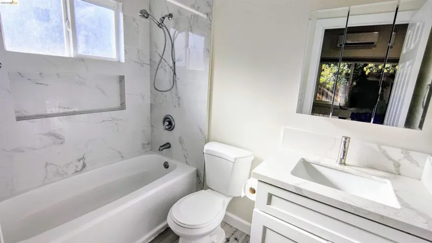 Full bath featuring vanity, shower / bath combination, and plenty of natural light