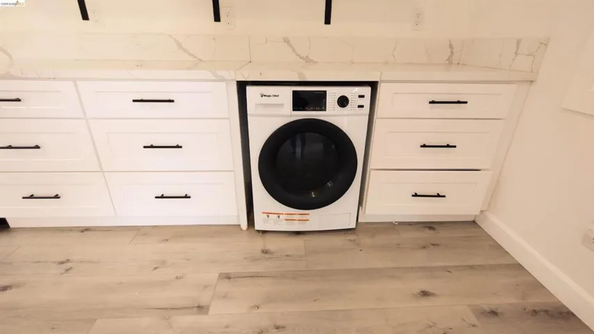 Laundry area featuring washer / clothes dryer and light wood-style floors
