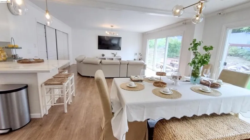 Dining space with light wood finished floors, ornamental molding, and suspended lighting