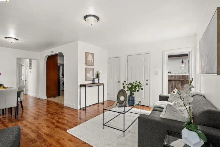 Living area featuring arched walkways and wood finished floors