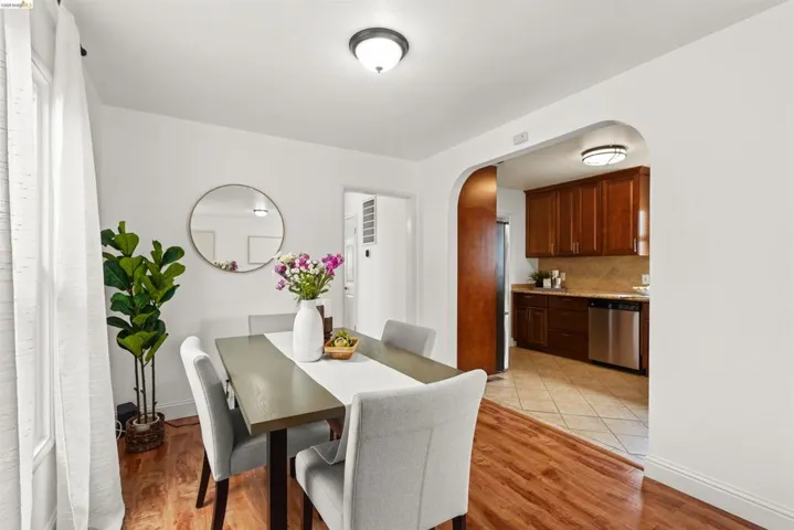 Dining space with arched walkways and light wood-type flooring