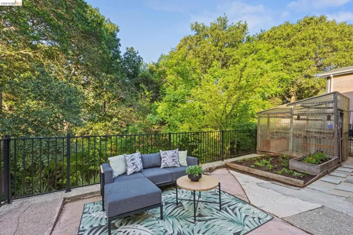 View of patio / terrace with a greenhouse, an outbuilding, outdoor lounge area, and a vegetable garden