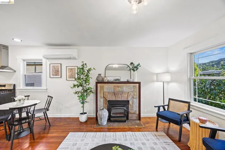 Living room with dark wood-style floors, a mini split for heating / cooling, and a tile fireplace
