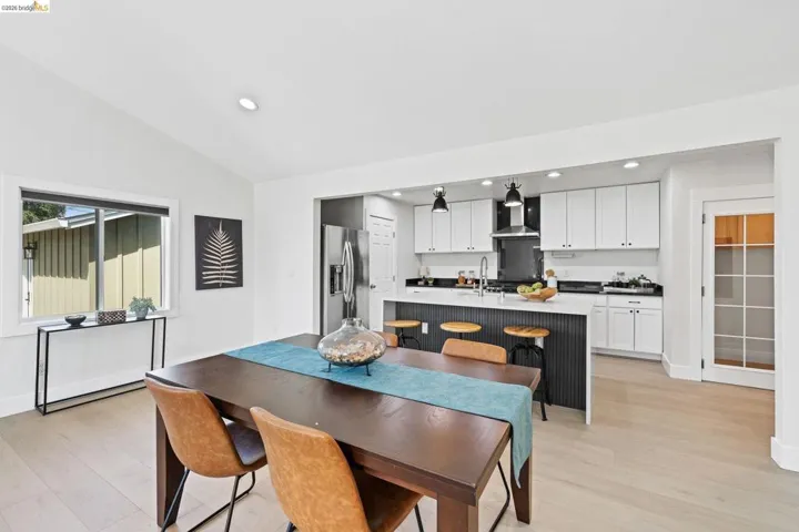 Dining room featuring light wood-style floors, lofted ceiling, and recessed lighting