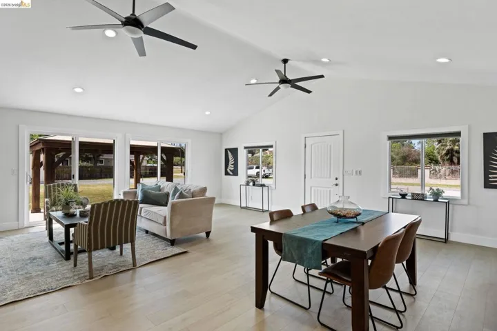 Dining space featuring light wood-style flooring, a high ceiling, ceiling fan, and recessed lighting