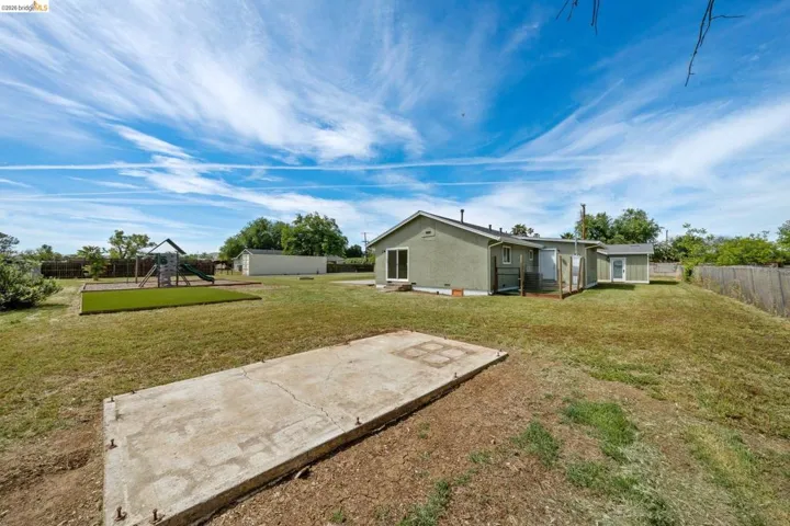 Back of property featuring a patio area, a fenced backyard, and a playground