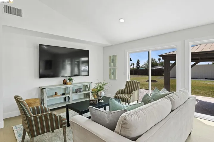 Living area with light wood-type flooring, lofted ceiling, and recessed lighting