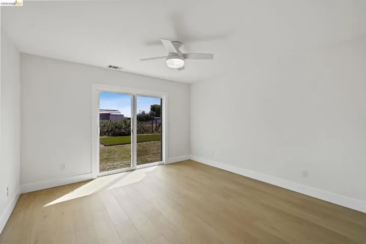 Unfurnished room with a ceiling fan and light wood-style floors