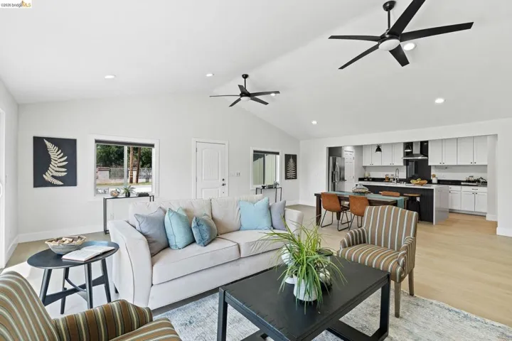 Living room featuring a ceiling fan, light wood-style flooring, recessed lighting, and vaulted ceiling