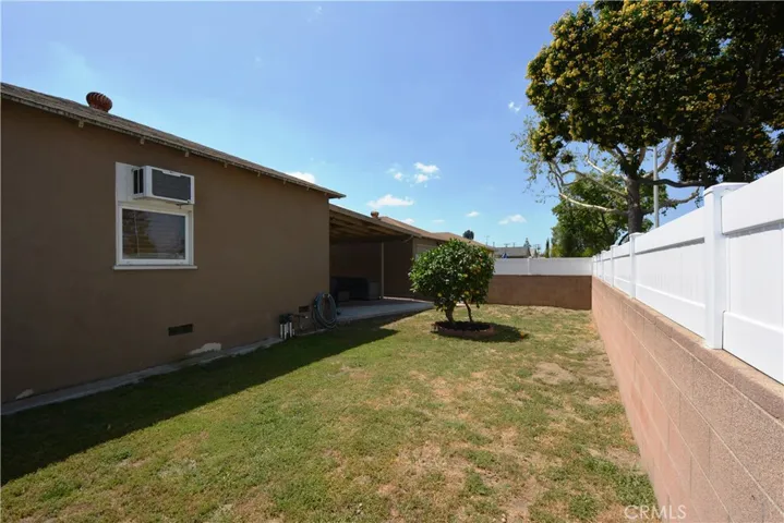 Spacious side yard features a citrus tree and tons of room for play!