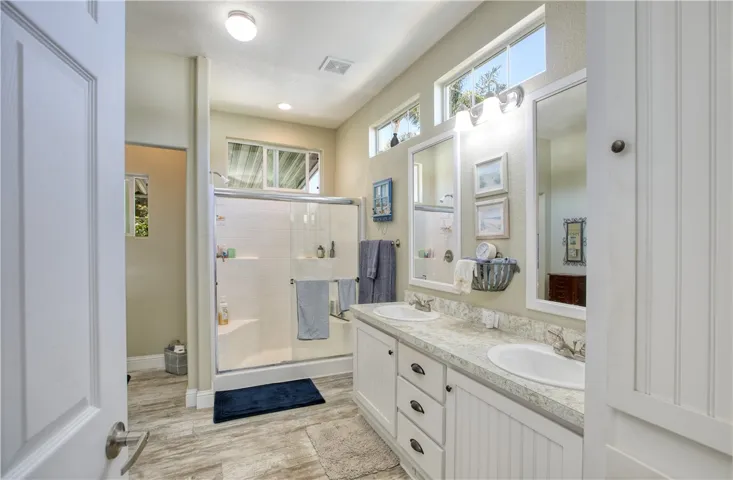 Primary bath with dual sinks, walk in shower and walk in closet.