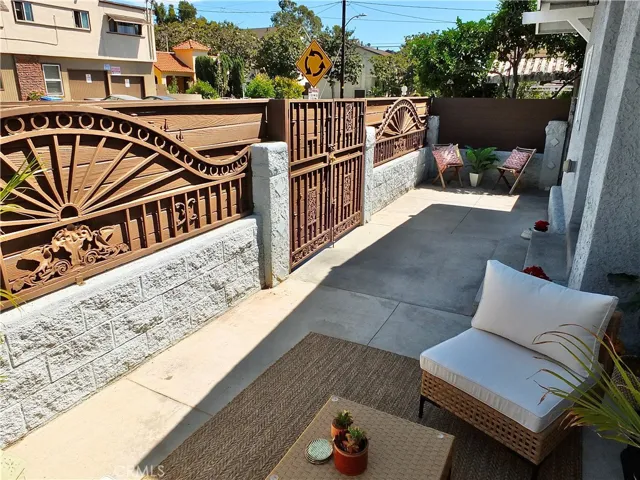 Long front patio with seperate seating areas.