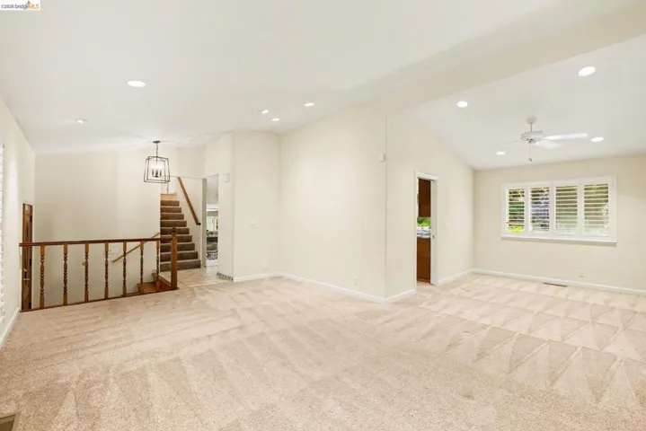 Living/Dining room featuring lofted ceiling, new carpet, recessed lighting, ceiling fan, dual pane windows and shutters