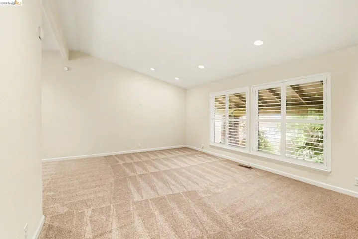 Living room featuring lofted ceiling, light colored carpet, and recessed lighting