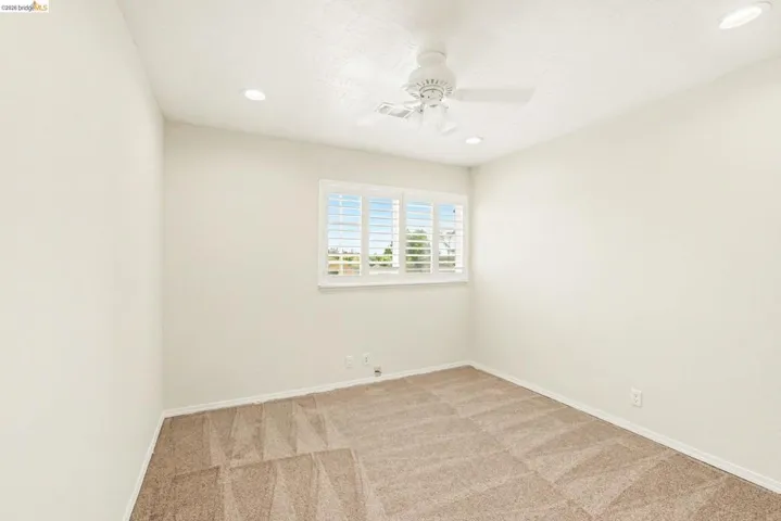 Upstairs s bedroom 1 with new carpet, ceiling fan, recessed lighting, shutters and dual pane windows.