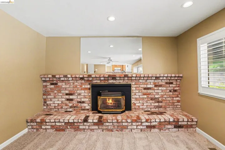 Detailed view of carpet, recessed lighting, and a brick fireplace with gas insert