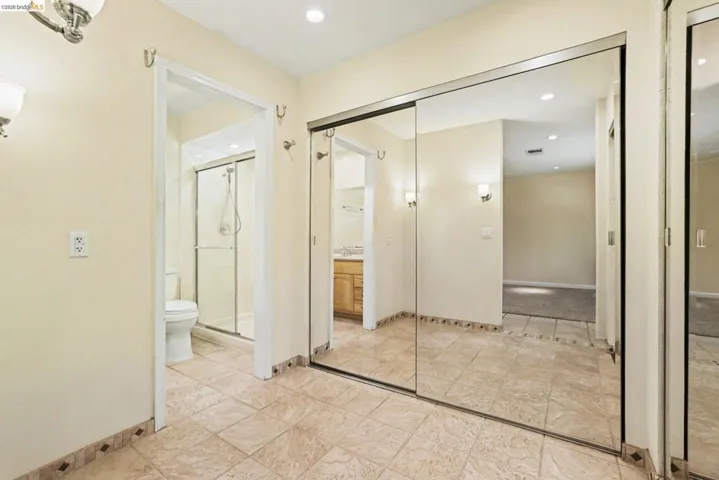 Full bath with a shower stall, vanity, and recessed lighting, mirrored closet doors.