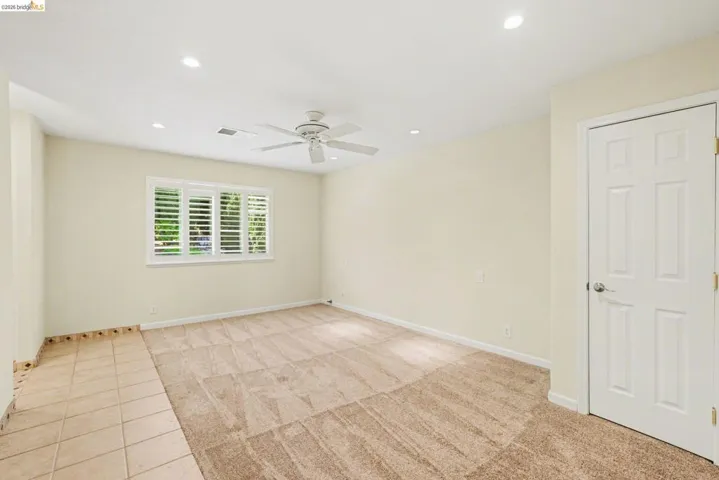 Master Bedroom with new carpet, tile, ceiling fan, recessed lighting, shutters and dual pane window.