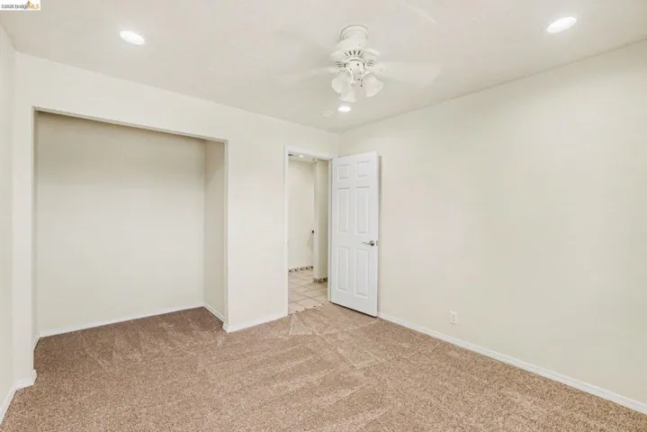 Bedroom 1 featuring a closet, new carpet, and recessed lighting shutters and dual pane window.