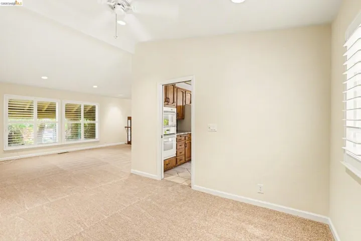 Dining room, recessed lighting, ceiling fan, new carpet, vaulted ceiling, shutters and dual pane windows.