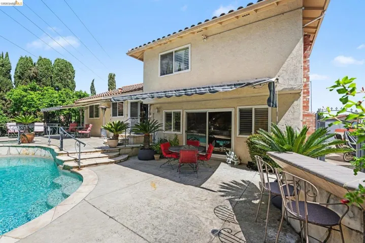 Back of house featuring a patio, outdoor dining area, stucco siding, and an outdoor pool