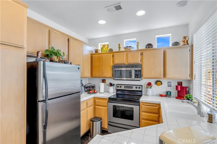 Kitchen features high ceilings, stainless appliances, recessed lighting, well maintained cabinetry, double sink with with window to the balcony.