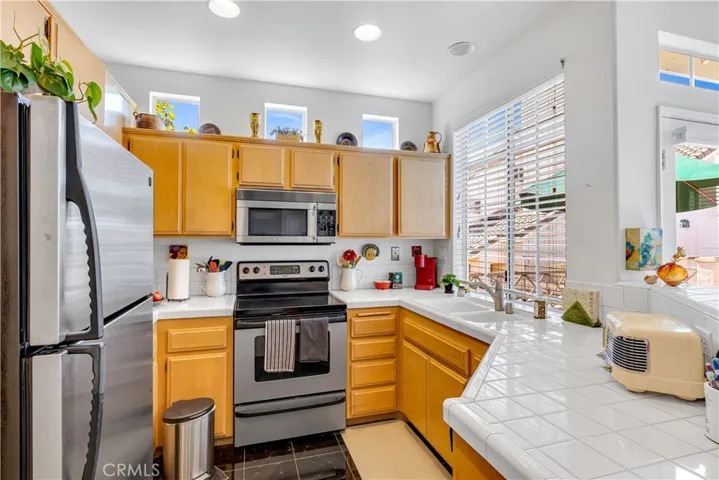 Black tile flooring and sparkling white tile presents a beautiful kitchen.