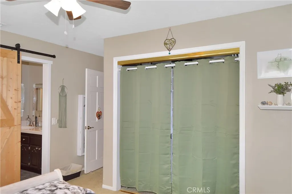 The 3rd bedroom features louvered shutters, ceiling fan, barn door to the "Jack and Jill" bath, and a closet organizer in the deep closet.