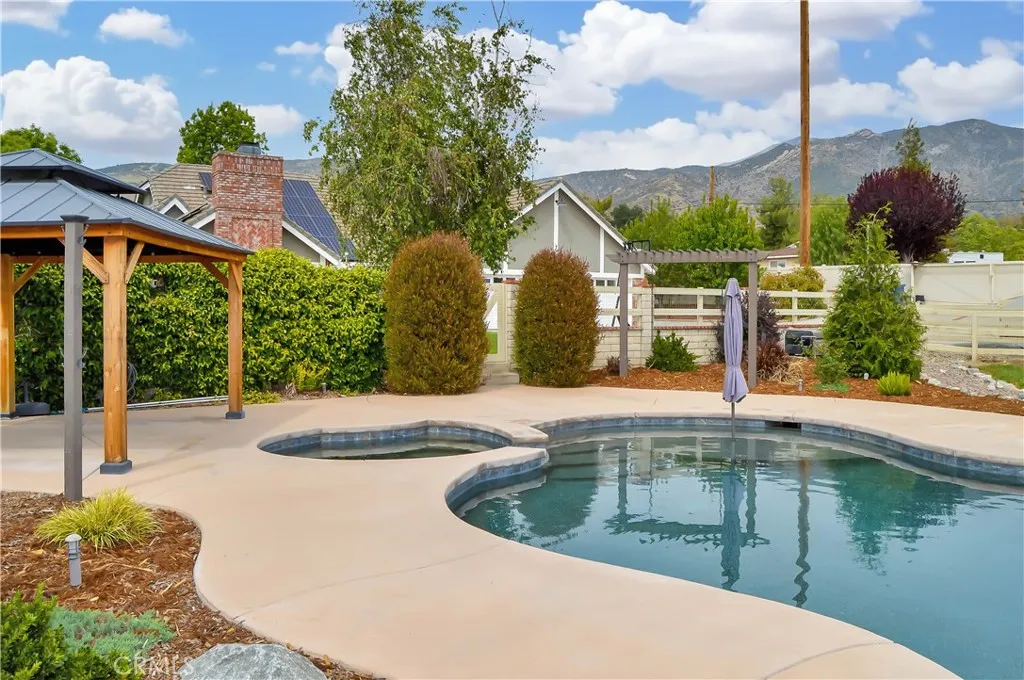 The sparkling pool and spa were built in 2021 and include a dark bottom PebbleTec surface for better heat retention (but they have heaters, too), a UV sterilization system, a water slide, a jumping rock, a Baja reef area with umbrella, a lighted gazebo with a fireplace included (fire added virtually), towel rack, concrete decking for sunbathing, lawn area for relaxing, and a handy storage shed. Pool party anyone?