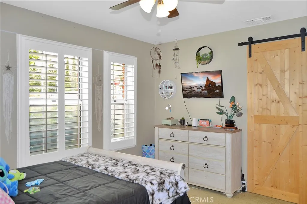The 3rd bedroom features louvered shutters, ceiling fan, barn door to the "Jack and Jill" bath, and a closet organizer in the deep closet. (Screen images added virtually)