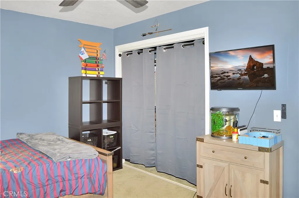The 2nd bedroom is across the hall from the main suite and offers barn door access to the "Jack and Jill" bath, louvered shutters, a ceiling fan, and a deep closet. (Screen image added virtually)