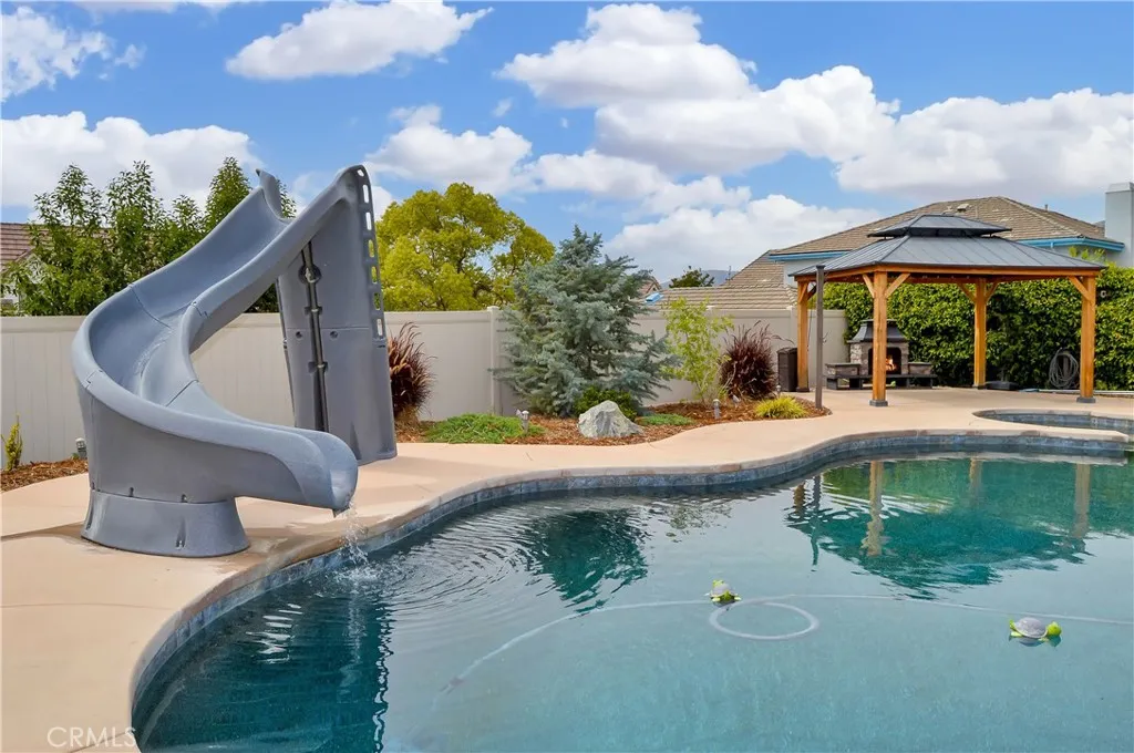 The sparkling pool and spa were built in 2021 and include a dark bottom PebbleTec surface for better heat retention (but they have heaters, too), a UV sterilization system, a water slide, a jumping rock, a Baja reef area with umbrella, a lighted gazebo with a fireplace included (fire added virtually), towel rack, concrete decking for sunbathing, lawn area for relaxing, and a handy storage shed. Pool party anyone?