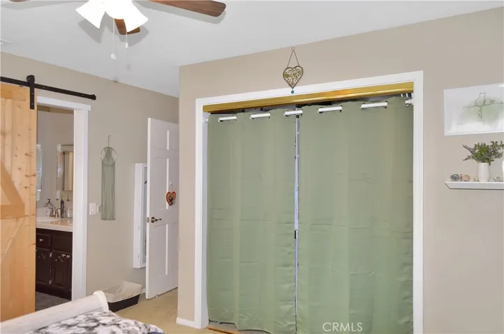 The 3rd bedroom features louvered shutters, ceiling fan, barn door to the "Jack and Jill" bath, and a closet organizer in the deep closet.