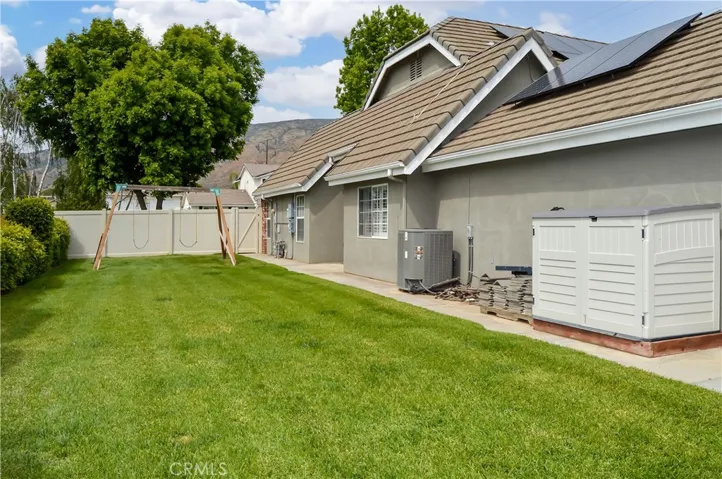 West side of the backyard with swing set and storage shed included