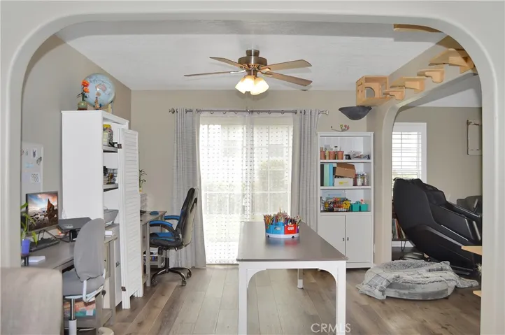 The dining room (used as an office/hobby space now) features arched entries from the living room and kitchen, more fabulous flooring, and a sliding door to the backyard