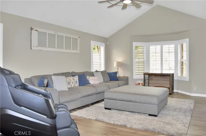 The living room is right next to the entry and features a stunning, custom built-in with heated fireplace, mantel, and display shelves, along with pet-friendly flooring, an impressive ceiling fan, and louvered shutters. The TV and extra-long couch are both negotiable.