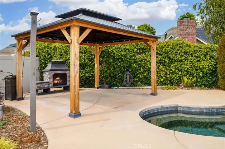 The sparkling pool and spa were built in 2021 and include a dark bottom PebbleTec surface for better heat retention (but they have heaters, too), a UV sterilization system, a water slide, a jumping rock, a Baja reef area with umbrella, a lighted gazebo with a fireplace included (fire added virtually), towel rack, concrete decking for sunbathing, lawn area for relaxing, and a handy storage shed. Pool party anyone?