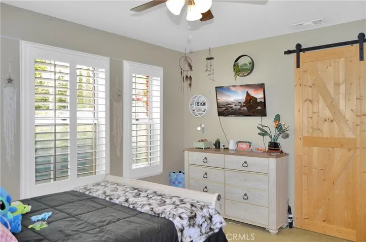 The 3rd bedroom features louvered shutters, ceiling fan, barn door to the "Jack and Jill" bath, and a closet organizer. (Screen images added virtually)